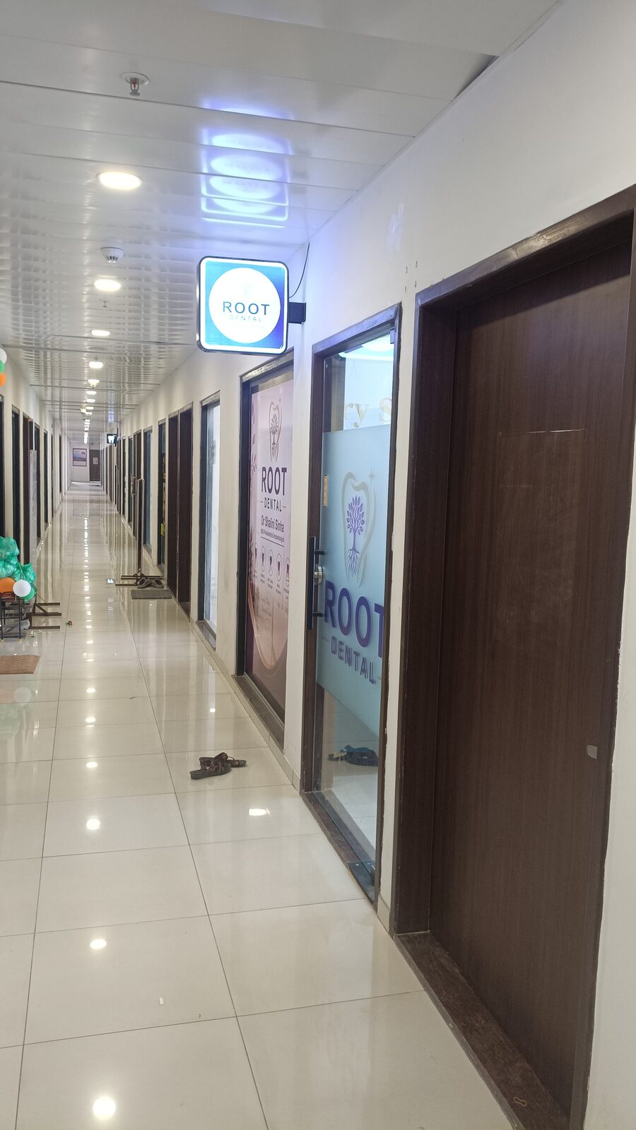 Building corridor with the illuminated Root Dental signage and glass entrance door